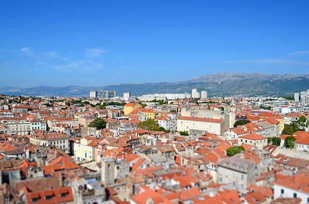 Miniature tilt-shift aerial view of Split, Croatia, showing charming red rooftops, historic Mediterranean architecture, and a vibrant urban landscape from a church tower.