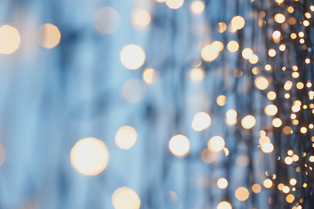 istock Bright golden bokeh lights on a cool blue background creating a serene and festive atmosphere. 2215440537