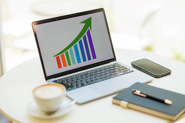 Professional working on a laptop indoors, analyzing financial data in a modern office  suitable for themes like finance, analytics, and corporate lifestyle