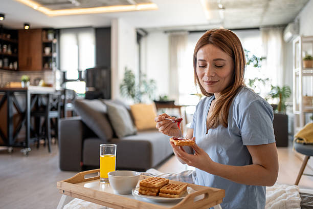 istock Woman enjoying waffles with jam for breakfast in bed 2215445224