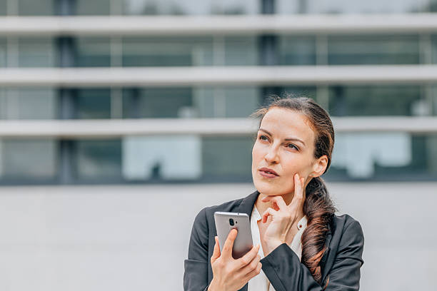 istock business woman with mobile phone and expression of doubt, decision or mistrust 2215445510