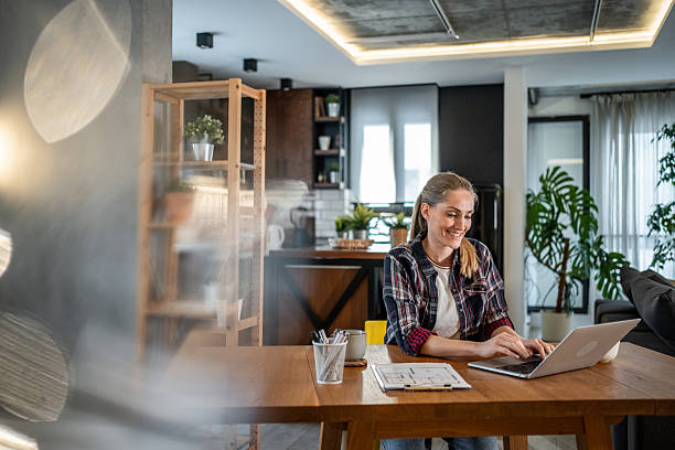 istock Architect working from home on a laptop and smiling 2215447050