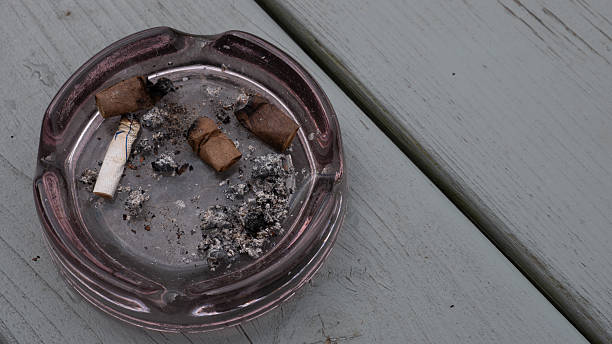istock Dirty Ashtray with Cigarette Butts and Ashes on Wooden Surface 2215447091