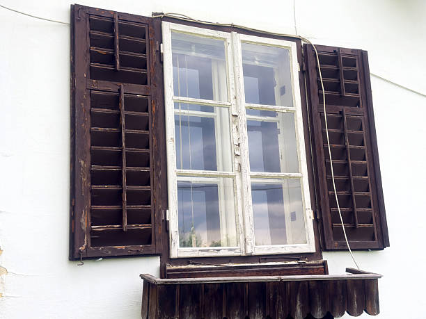 Vintage wooden shuttered window with peeling paint and reflection, lifestyle