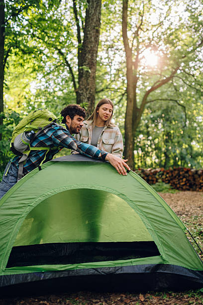 istock Hikers setting up tent in forest campsite during summer vacation 2215455006