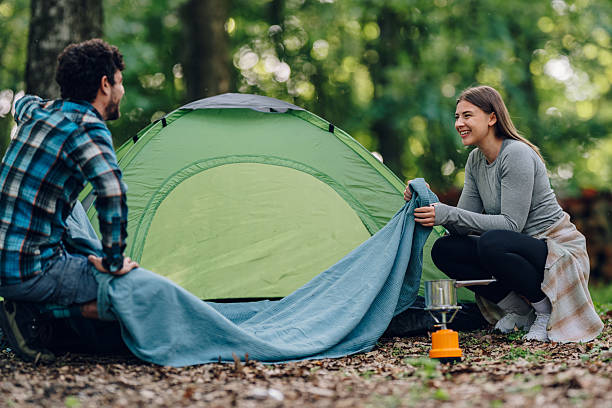 istock Couple preparing campsite and tent in forest 2215455008