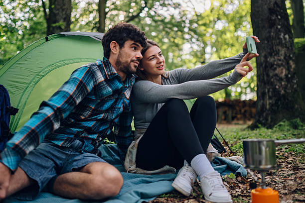 istock Couple taking a selfie while camping in the forest 2215455022