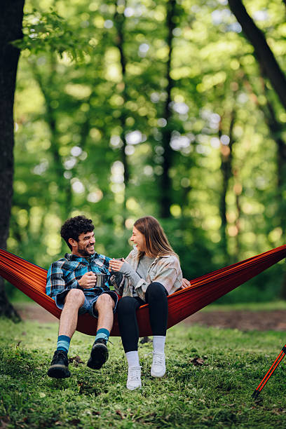 istock Couple relaxing in hammock, drinking coffee and enjoying nature 2215455072