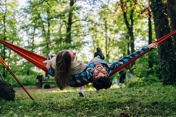 istock Happy campers relaxing in hammock in forest 2215455079