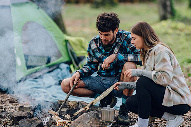 istock Campers lighting a firewood for cooking in campsite 2215455611