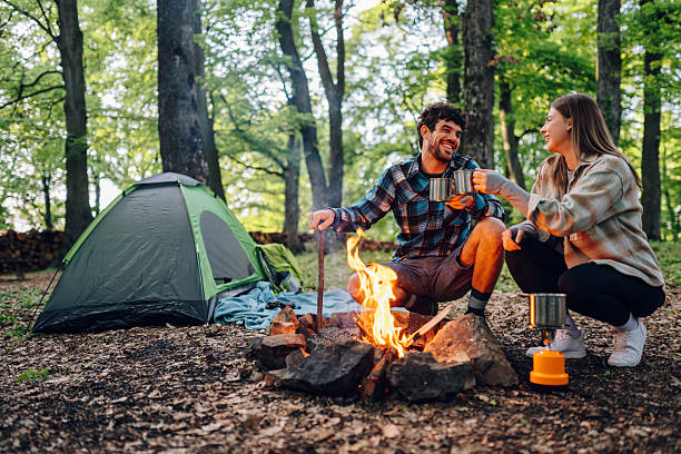 istock Hikers enjoying hot drinks by campfire in forest 2215455628