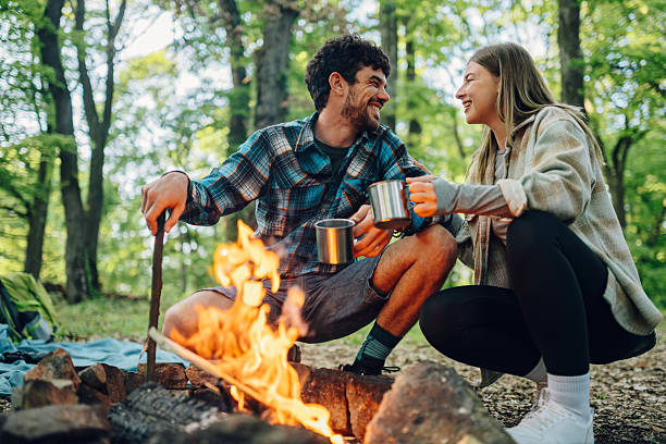 istock Hikers enjoying hot drinks by campfire in forest 2215455631