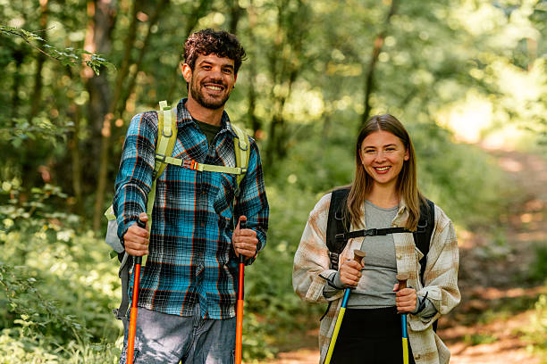 istock Hikers walking through forest trail using trekking poles 2215455689