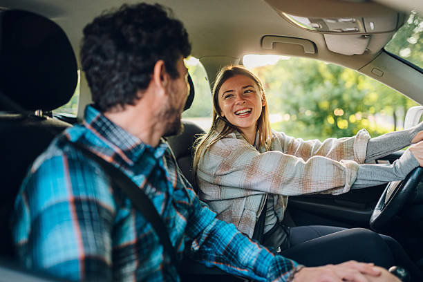 istock Young couple having fun while driving in car 2215455691