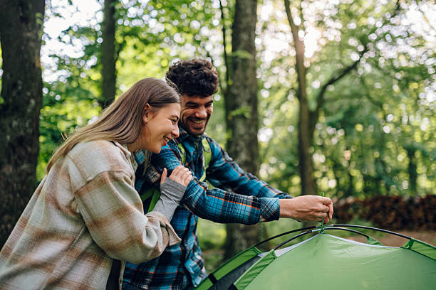 istock Hikers smiling and setting up tent in forest 2215455801
