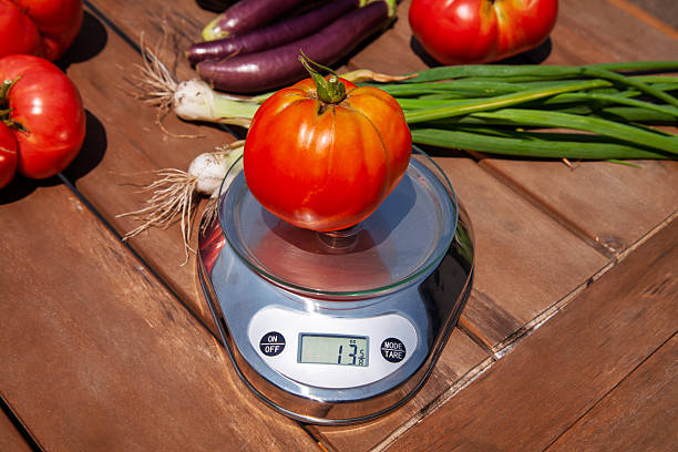 istock Freshly harvested tomatoes and vegetables being weighed outdoors in a garden setting 2215459505