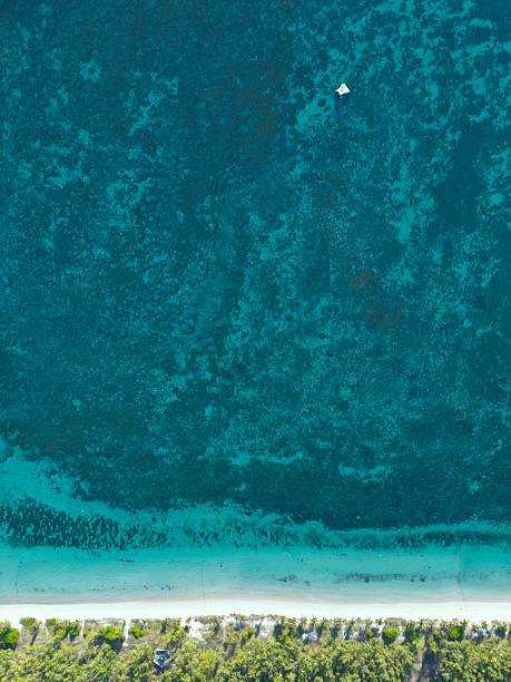 istock Lone Boat Over Turquoise Reef 2215459635
