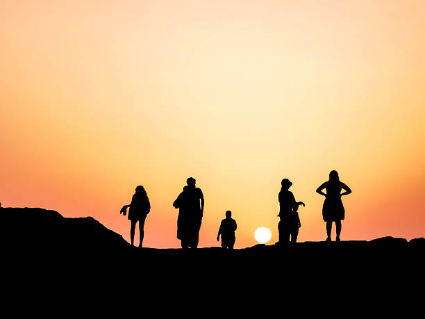 istock group of people enjoying sunset at a rocky beach 2215459963