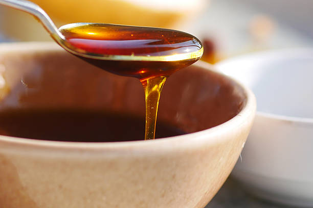 istock Honey being drizzled from a spoon into a bowl 2215460076
