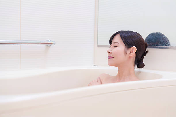 Middle woman relaxing in a bath at home