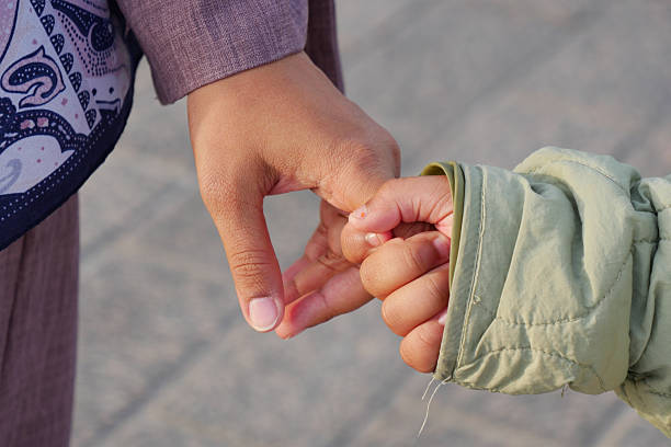 istock Holding hands between parent and child on a sunny day 2215462367