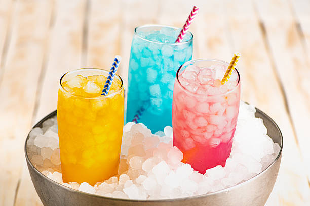 istock Several glasses with ice and assorted colorful flavored sodas, inside a metal bowl overflowing with ice for chilling, close-up. 2215465828