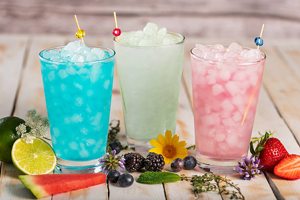 istock Several glasses of iced soft drinks in various flavors, with blackberries, blueberries, strawberries, lime, and watermelon on a white wooden table, close-up. 2215465849