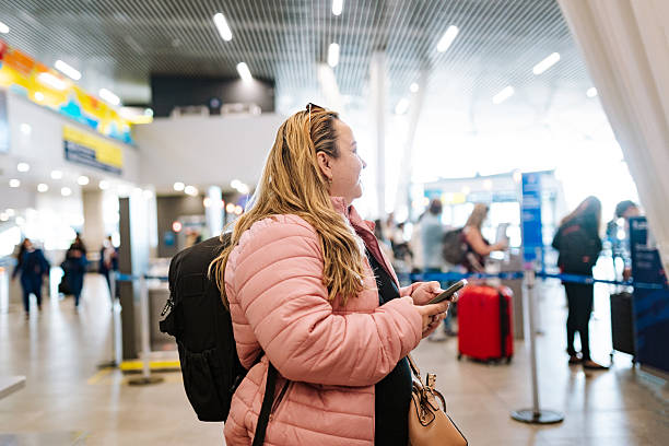 istock Female traveler checking phone before boarding 2215466035