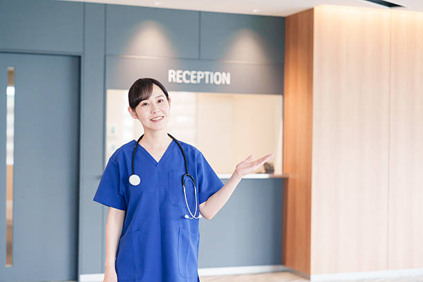 患者を迎える女性医療従事者 - 病院 ストックフォトと画像