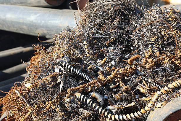 A close-up view of metalworking production waste, including a chaotic pile of fine iron filings and larger metal shavings.