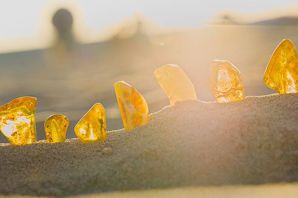 istock Glowing amber rests on sand as the sun sets over Koobrzeg, casting warm evening light. 2215470209