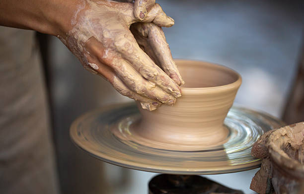 istock Potter's hands working clay on a potter's wheel 2215471959