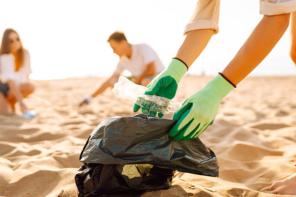 istock Young friends actively participate in beach cleanup. 2215476892