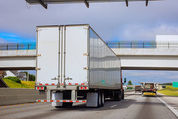 istock Trucks navigating busy highway under an overpass during daylight hours in suburban area 2215477859