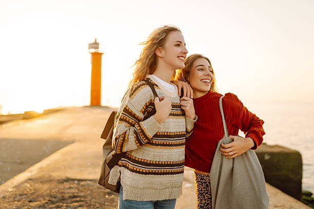 istock Girlfriends walking along the pier and having fun together at sunset. 2215479617