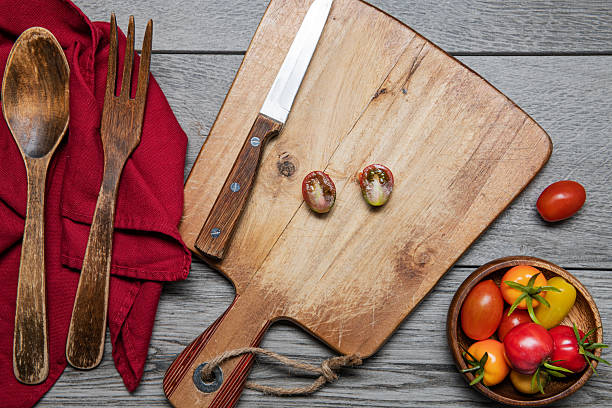 istock cherry tomatoes on a cutting board on a gray wall table. View from above. 2215480686