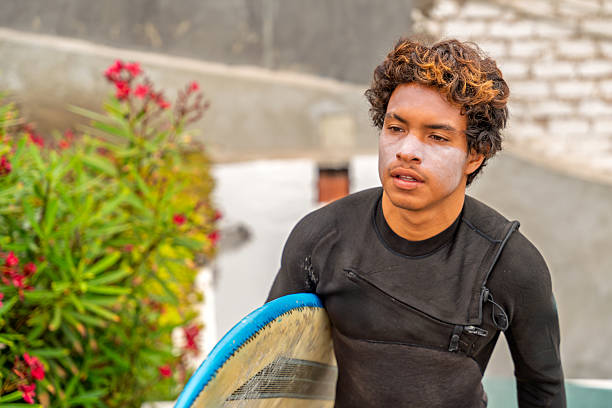 Young surfer walking with his surfboard under his arm, heading to the beach for a surf session