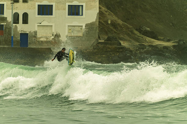 A surfer launches boldly against a fiery sky, embodying the thrill of nature and sport.