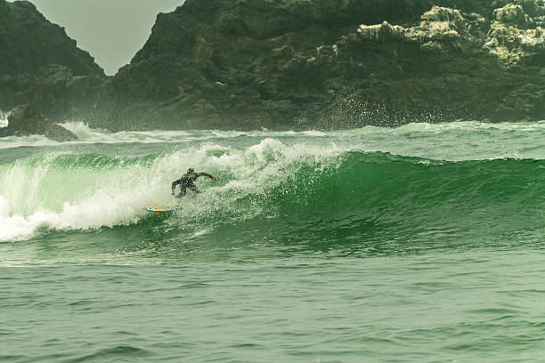 istock Surfer riding a big green wave on a cloudy morning 2215483966