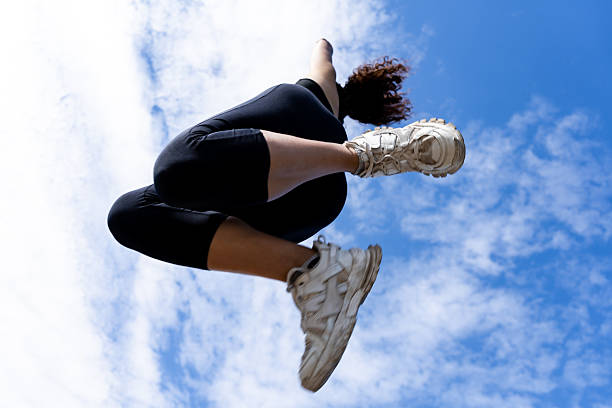 Kid performing a powerful jumping, only legs visible, symbolizing energy and urban culture.