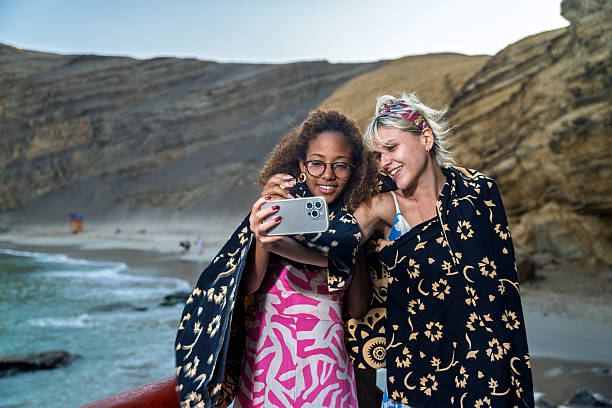 istock Two young women taking a selfie leaving the beach 2215485090