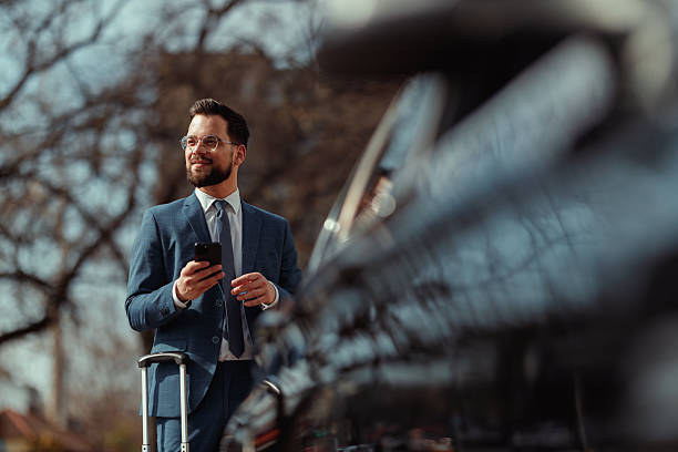 istock Businessman With Suitcase Checking Phone 2215487291