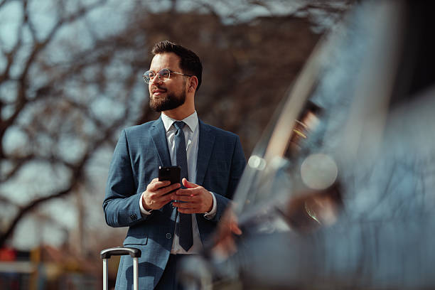 istock Businessman With Suitcase Checking Phone 2215487297
