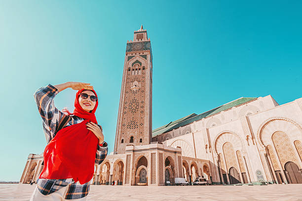 istock Smiling tourist with red hijab and sunglasses shielding her eyes from the sun while visiting the Hassan II Mosque in Casablanca, Morocco 2215487875