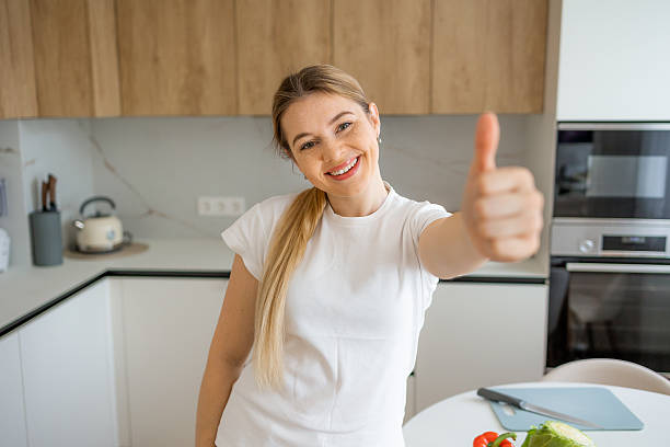 istock A cheerful woman giving a thumb up in a bright home kitchen 2215488418