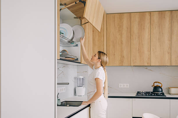 istock Woman organizing kitchen shelves in a modern home interior 2215488423