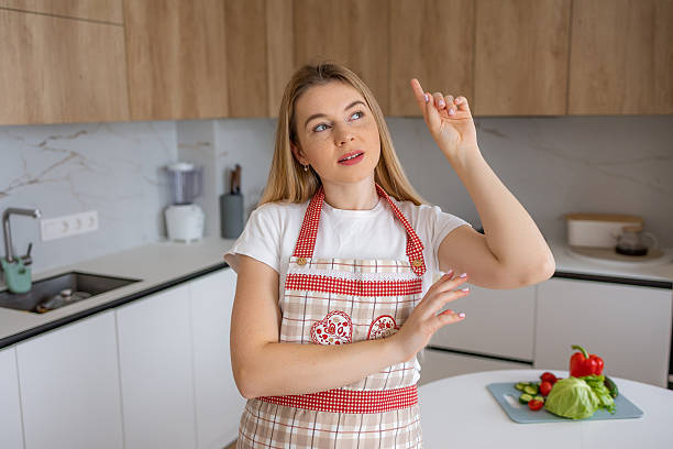 istock Woman in modern kitchen thinking while preparing fresh vegetables for cooking 2215488453