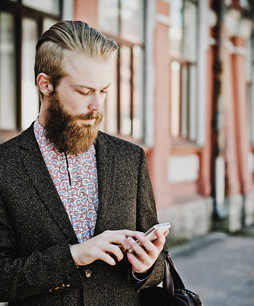 istock Young bearded man with mobile, outdoor 2215493706