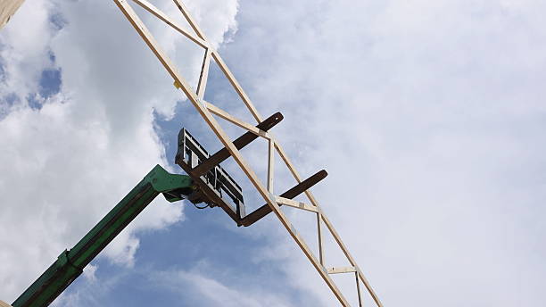 istock Construction crew uses equipment to lift wooden beams for building structure 2215496449