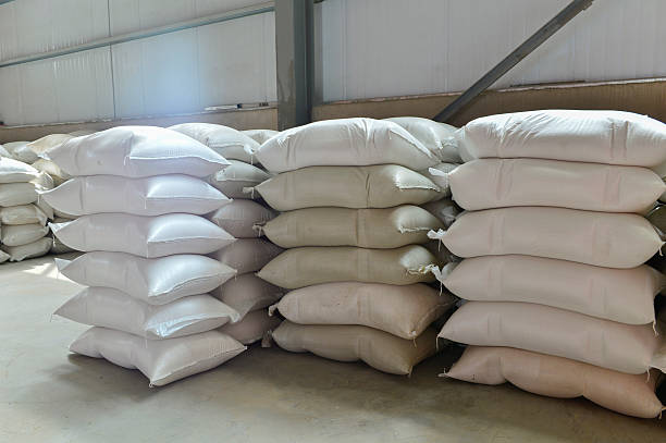 istock Many rows of plastic white sacks with goods are in big warehouse 2215500390